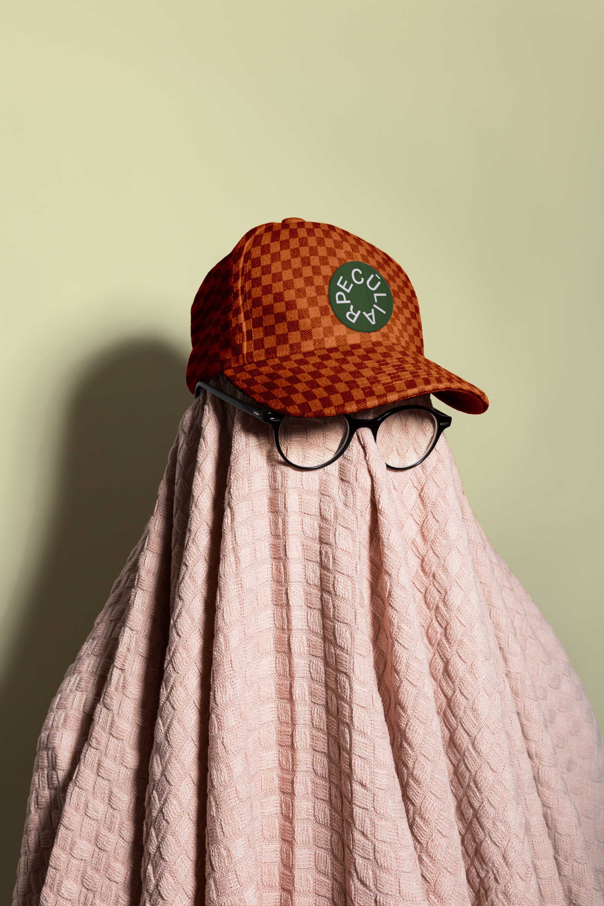 Mockup of a covered person with eyeglasses and a baseball hat on a studio background, in use example.