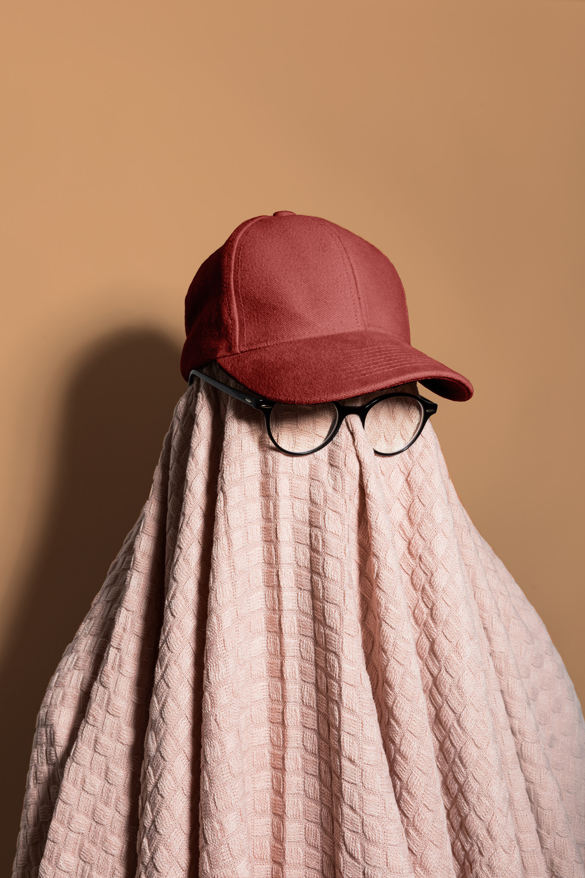 Mockup of a covered person with eyeglasses and a baseball hat on a studio background, empty mockup.