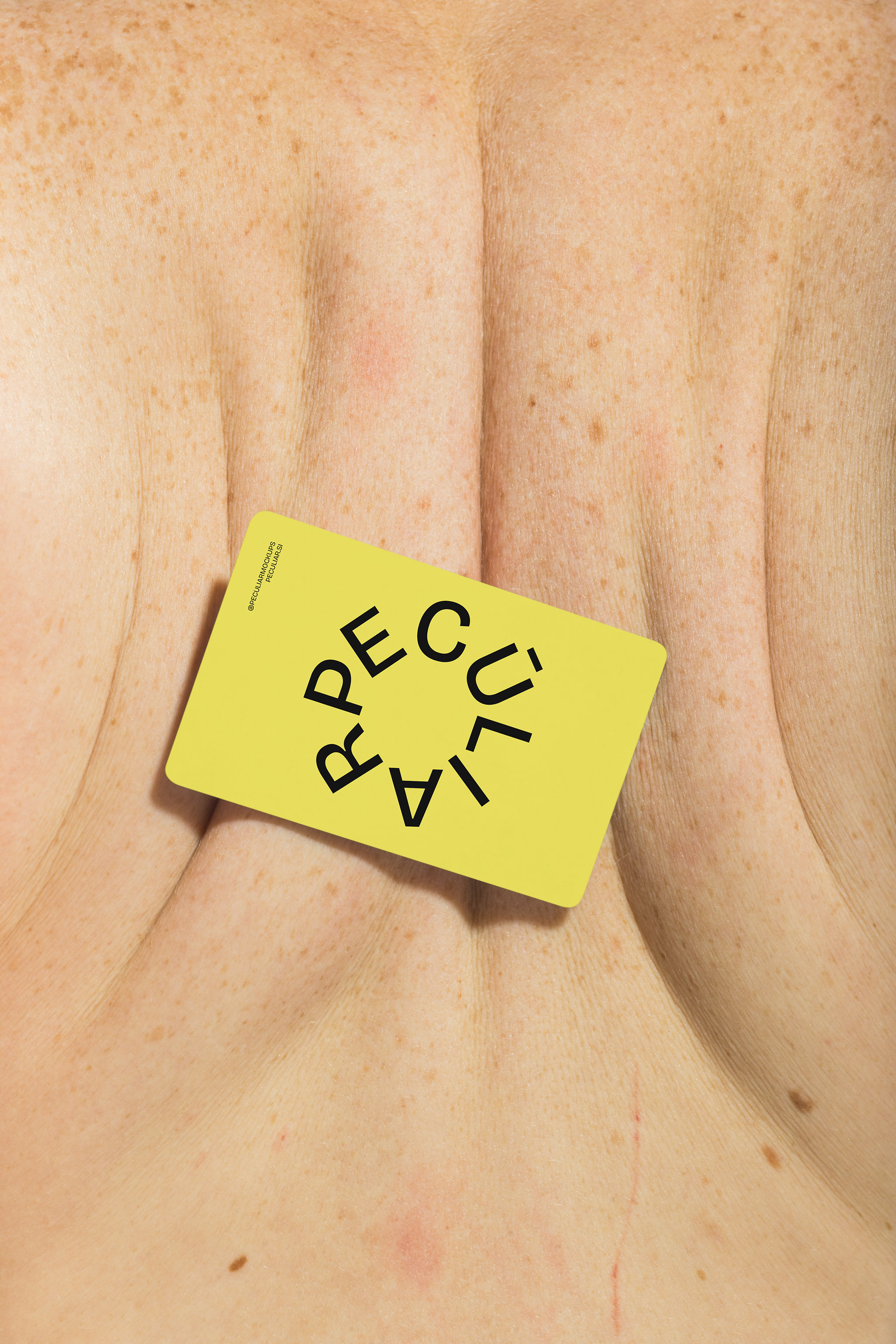 Business card mockup placed on a person's bare muscular back, suggesting weightlifting and fitness, in use example.