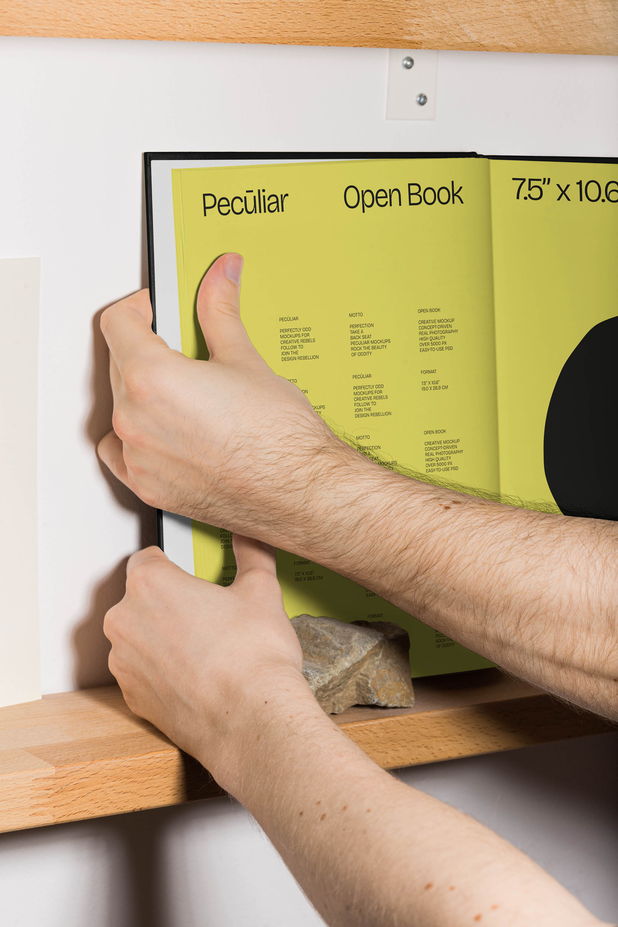 Two hands holding an open book mockup on wooden bookshelves, in use example.
