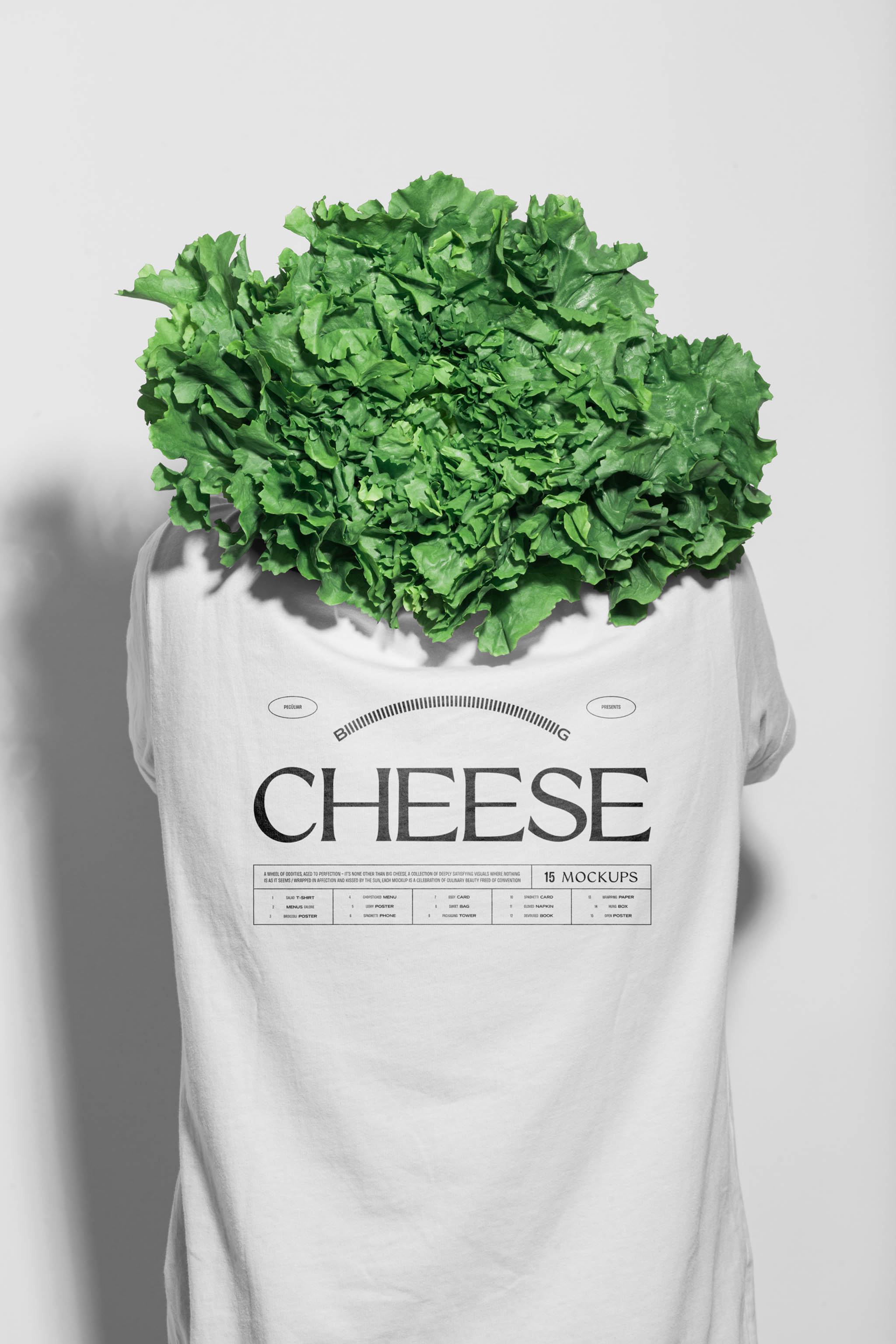 Photo of a person's back wearing a white minimal cotton t-shirt mockup with central black typographic design and a salad head, in use example.