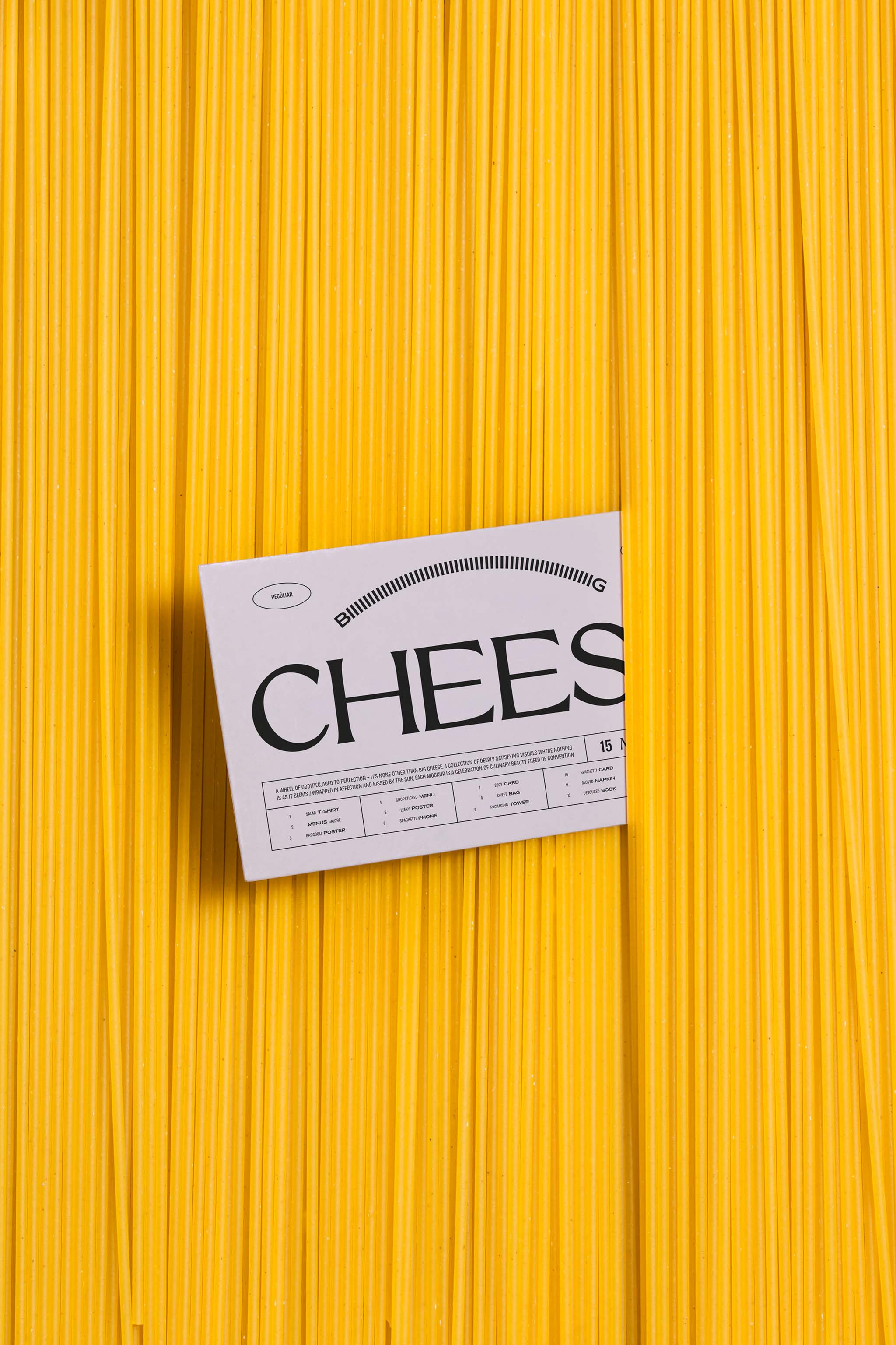 Food photo mockup close-up of vertically aligned spaghetti amid which a business card with black serif design is placed, in use example.